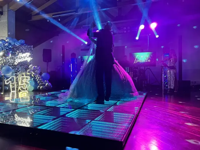Celebración de quince años con pantallas LED, pista iluminada e invitados en la pista