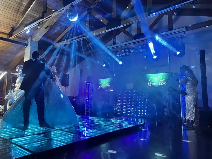 Salón de una fiesta de quince años con pantallas LED y luces robóticas azules