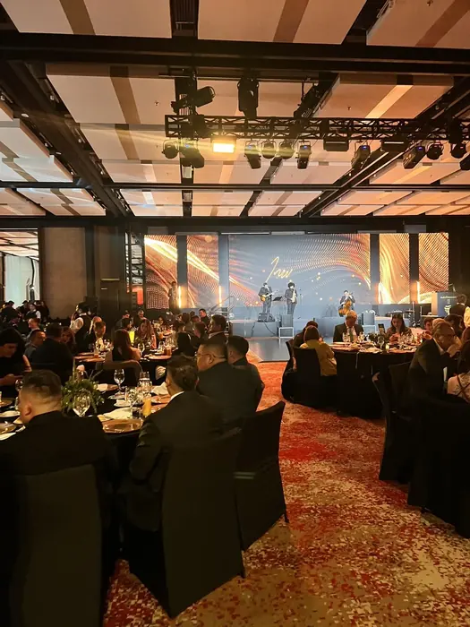 Banquete de gala en Bogotá con las mesas montadas frente a una pantalla LED panorámica