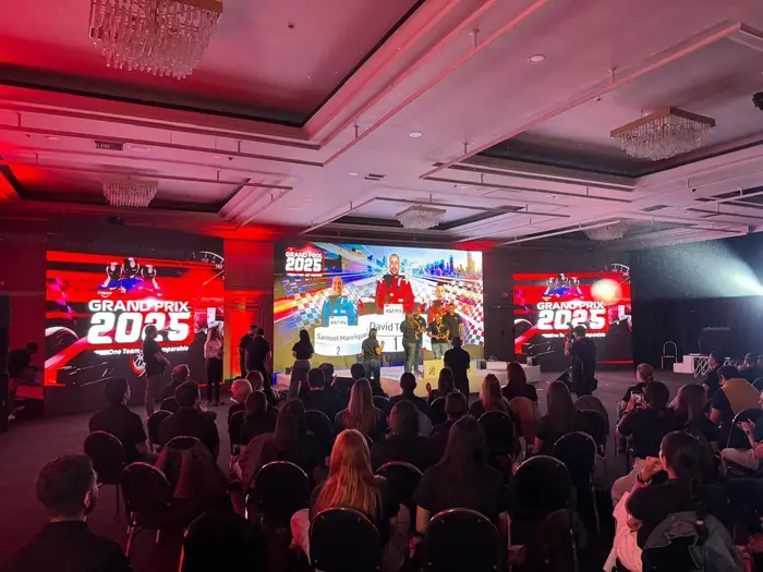 Escenario corporativo con pantalla LED central y pantallas laterales durante una premiación