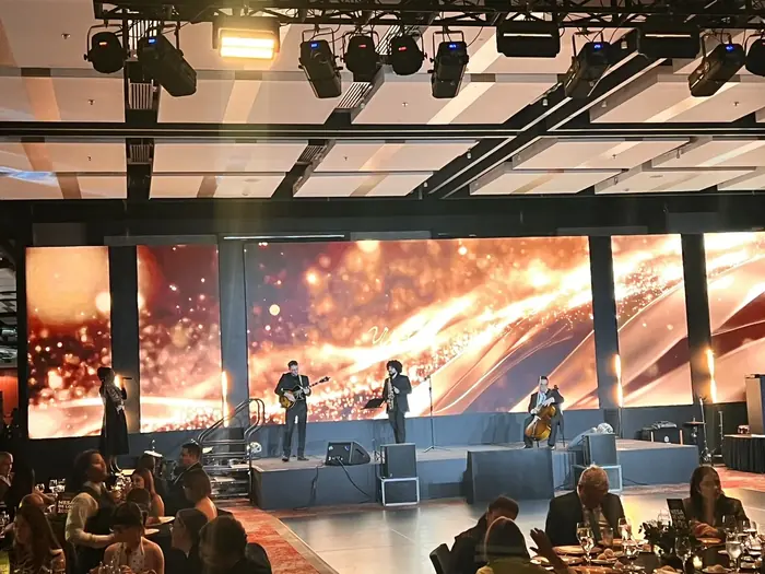 Músicos en vivo sobre la tarima con una pantalla LED panorámica de fondo