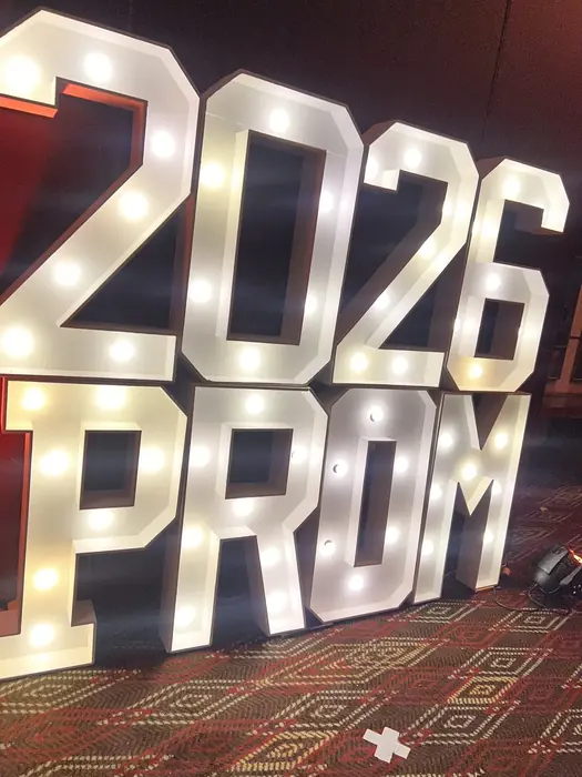 Letras gigantes iluminadas con el año de graduación junto al montaje de pantallas LED