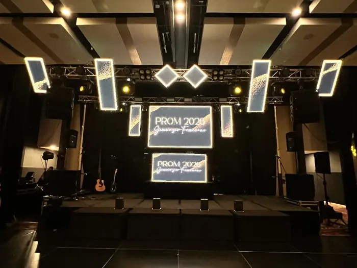 Montaje de pantallas LED verticales colgantes y pantalla central para una fiesta de grados