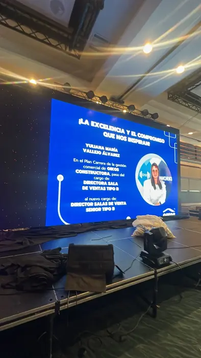 Pantalla LED mostrando la ficha de una persona premiada durante un evento empresarial