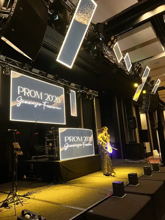 Cantante en vivo sobre la tarima de una fiesta de grados con pantallas LED de fondo