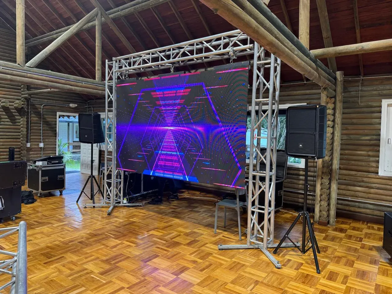Pantalla LED sobre estructura de truss con las cajas de sonido a los lados, montada en un salón de eventos