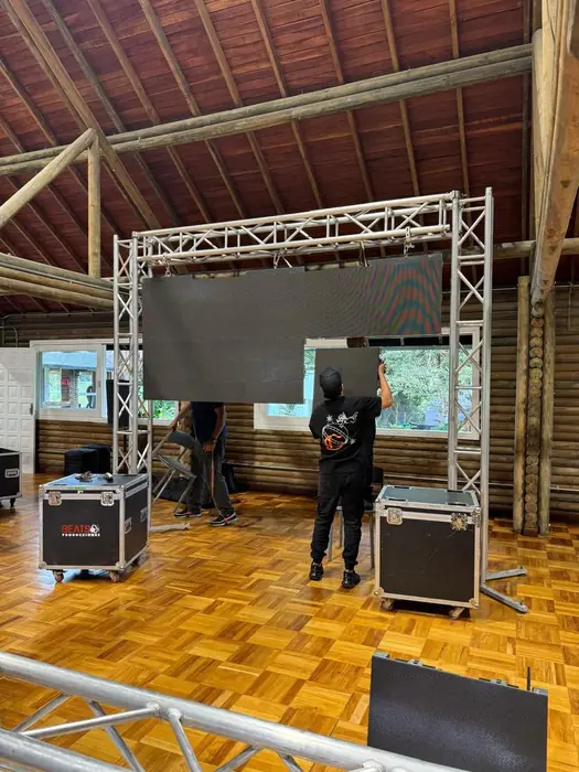 Técnicos de VoiZ armando una pantalla LED con los flight cases de transporte abiertos