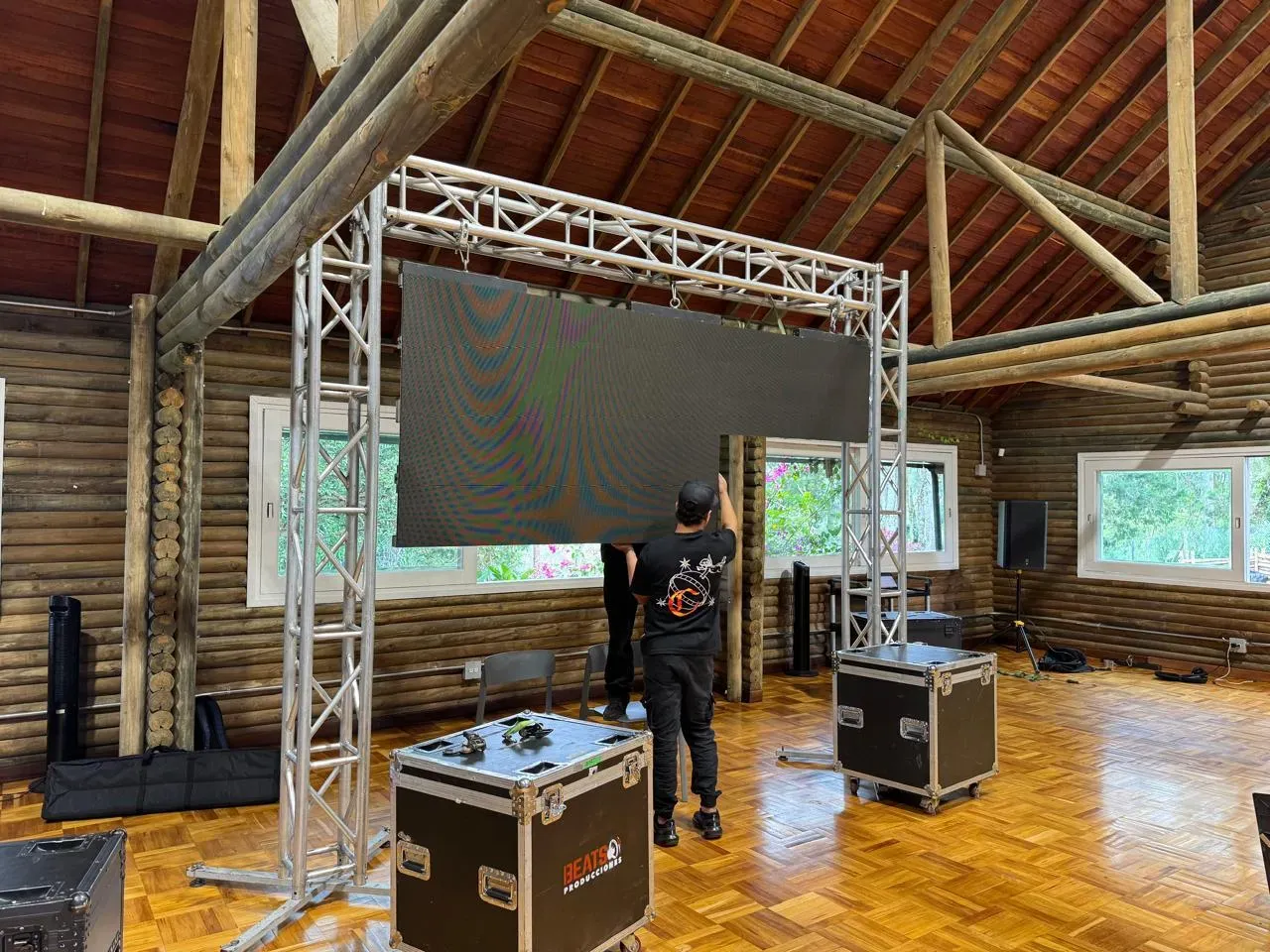 Técnico ajustando los módulos de una pantalla LED sobre la estructura de truss durante el montaje