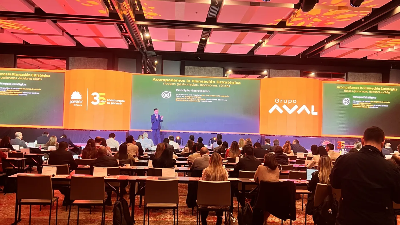 Pantalla LED panorámica durante un congreso corporativo en Bogotá, con el público en mesas