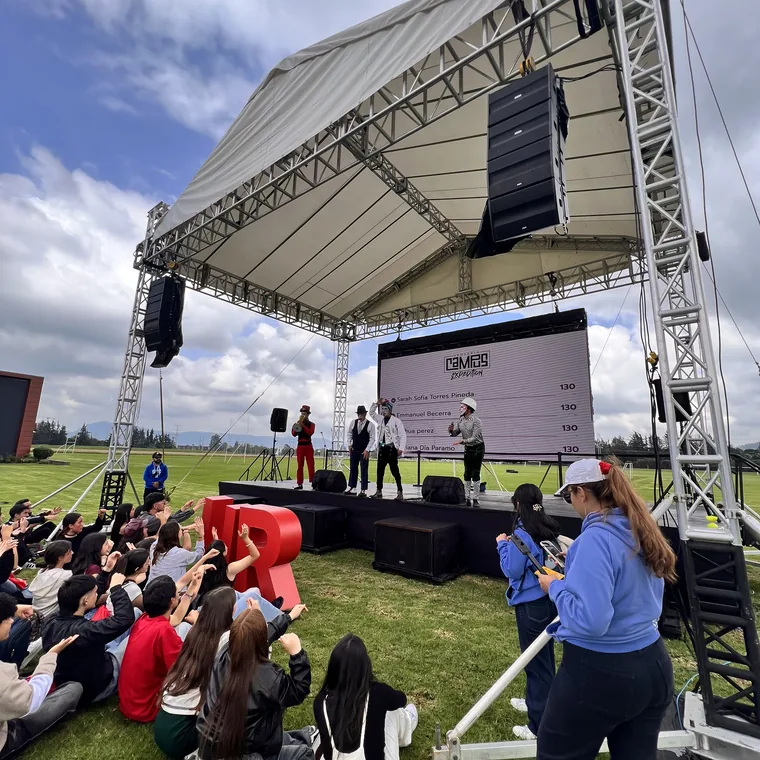 Escenario al aire libre con pantalla LED, line array y estructura de truss bajo carpa
